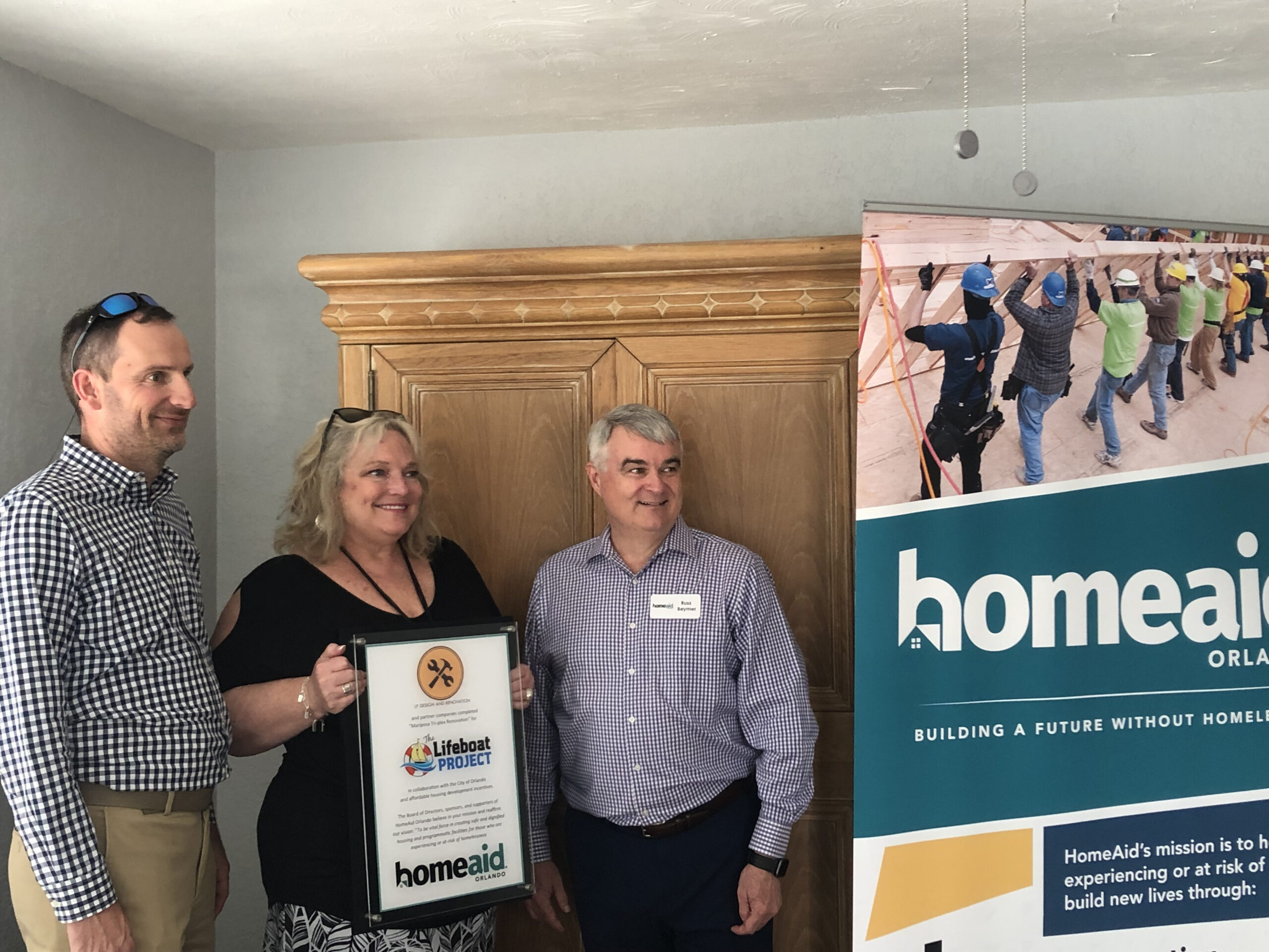 Jill Cohen, CEO of The Lifeboat Project is surrounded by Peter Leerdum of LP Design and Renovation and Russ Beymer from Homeaid Orlando during the opening of the Low Income Housing Project in Downtown Orlando